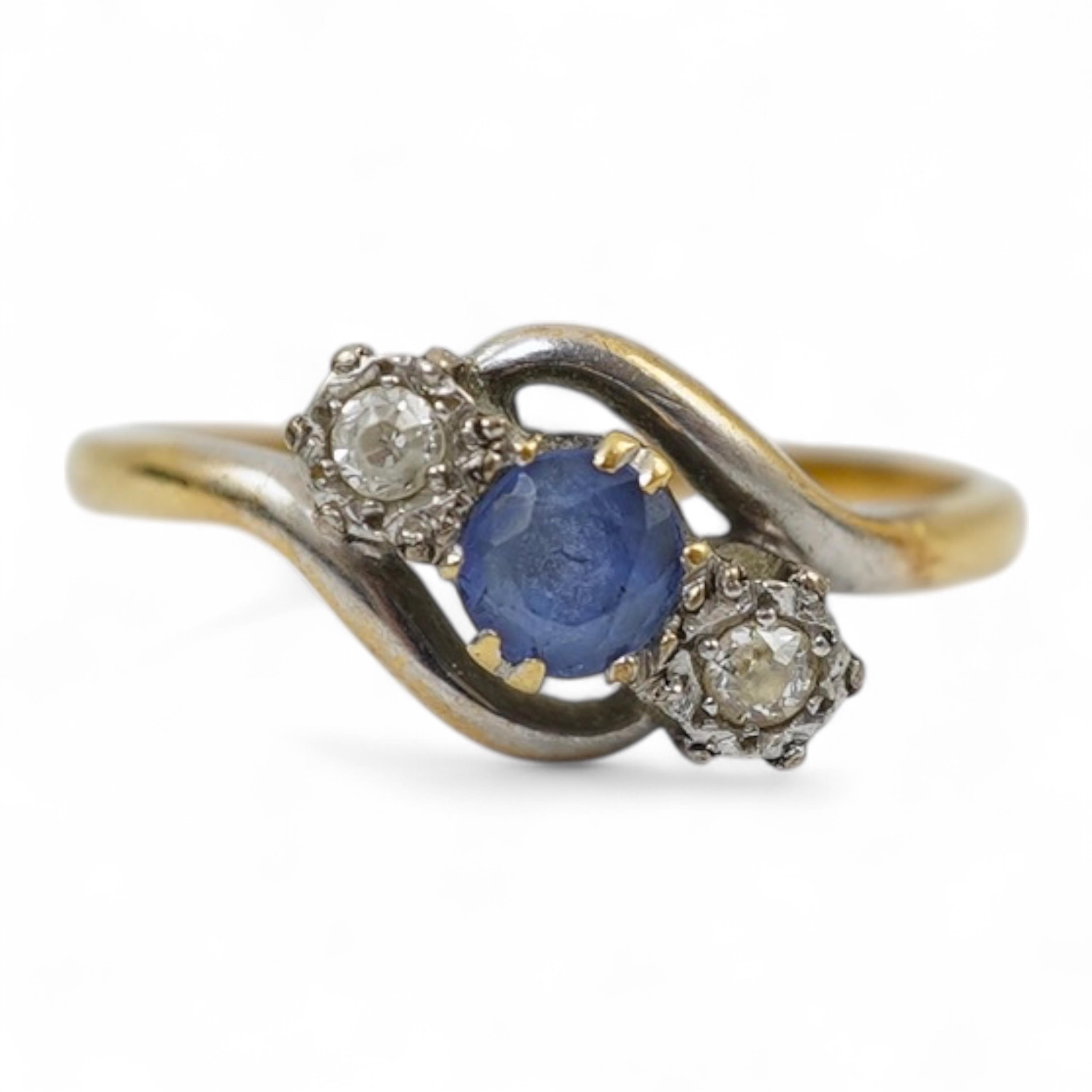 An early 20th century 18ct gold, sapphire and diamond set three stone crossover ring, size P/Q, gross weight 2.4 grams.